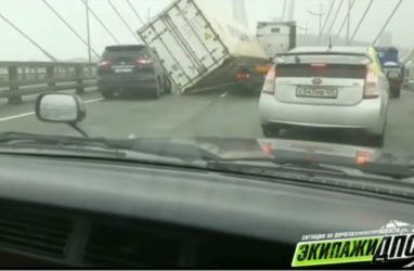 «Мост качает»: ураганный ветер во Владивостоке снёс контейнер с большегруза на другое авто