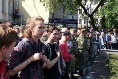 Молодые люди и казаки наблюдают на происходящим на площади