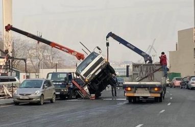 Во Владивостоке автокран опрокинулся на микрогрузовик