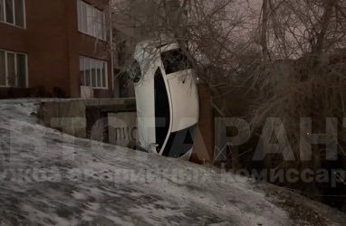 Колёсами в небо: во Владивостоке машина вертикально застряла на ледяном спуске